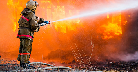 firefighter putting out a building