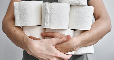 Man carrying several rolls of toilet paper