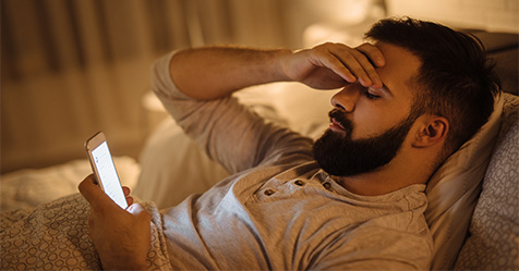 frustrated man reading a text message at night